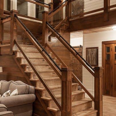 Wooden staircase with glass panel infill, square newel posts and black metal handrail Wooden staircase with glass panel infill, square newel posts and black metal handrail