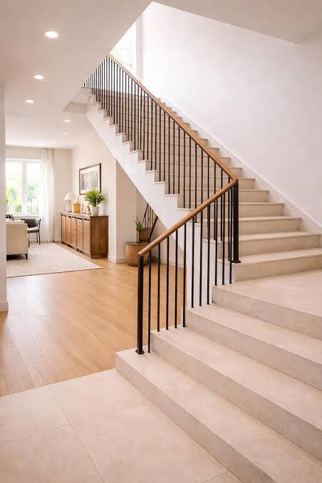 Light hardwood handrail with thin black metal square balusters on stone stairs Light hardwood handrail with thin black metal square balusters on stone stairs
