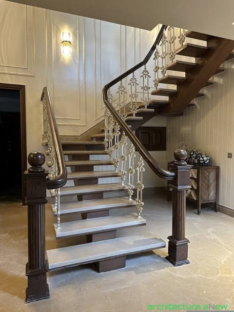 Luxury dark wood handrail with ornate white scroll metal balusters and fluted newels Luxury dark wood handrail with ornate white scroll metal balusters and fluted newels
