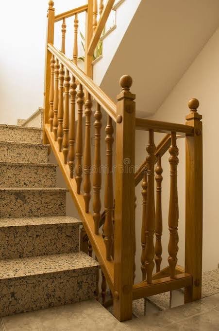 Traditional honey-finished wooden railing with turned balusters and ball finials Traditional honey-finished wooden railing with turned balusters and ball finials